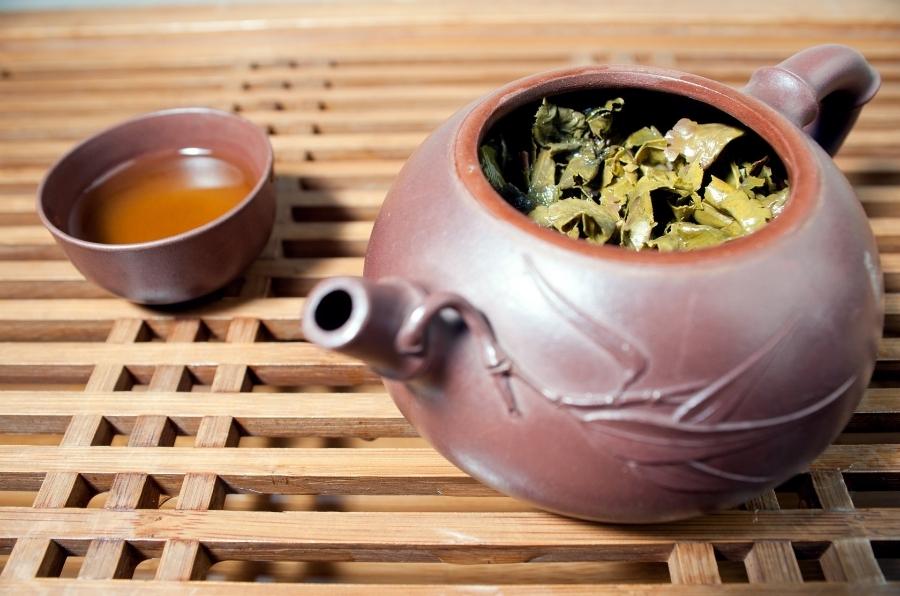 Non-glazed tea pot full of tea leaves.