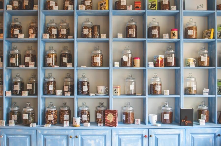 Tea containers inside a tea shop, on a shelf.