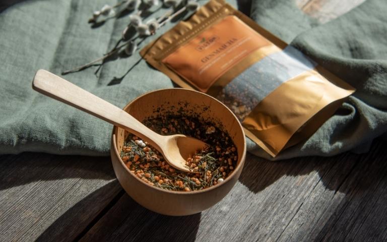 A bowl of genmaicha tea and a bag of Viston genmaicha tea in the background.