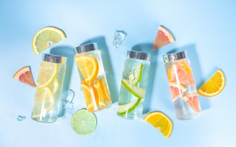 Bottles of water with pieces of fruit.