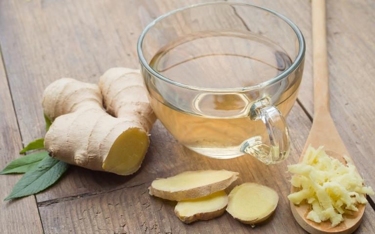Ginger root and a cup of ginger infusion.